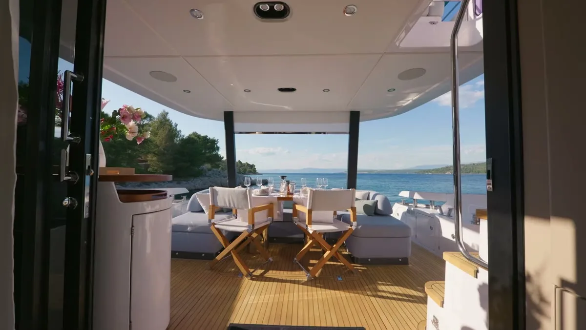The aft-deck table set for dinner, the bay beyond